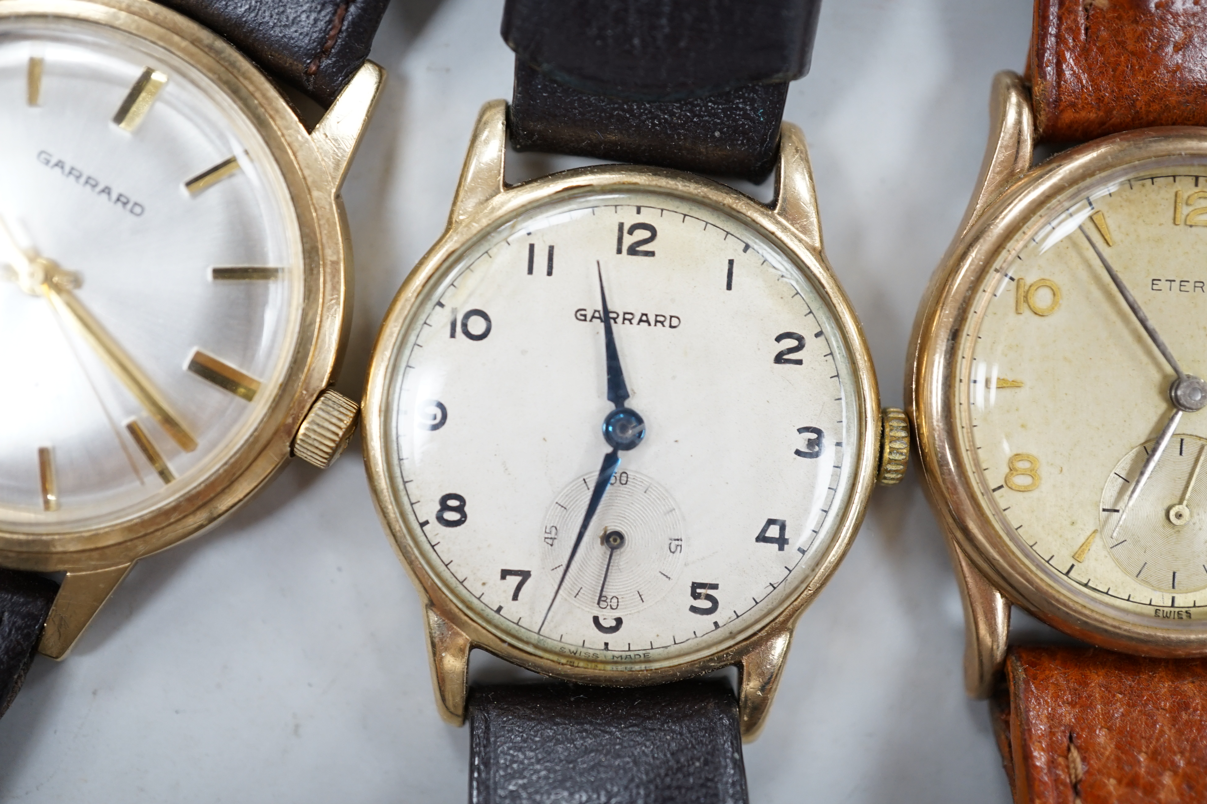 Two gentleman's 9ct gold manual wind wrist watches, retailed by Garrards, both with engraved inscription and two other 9ct gold wrist watches including Eterna.